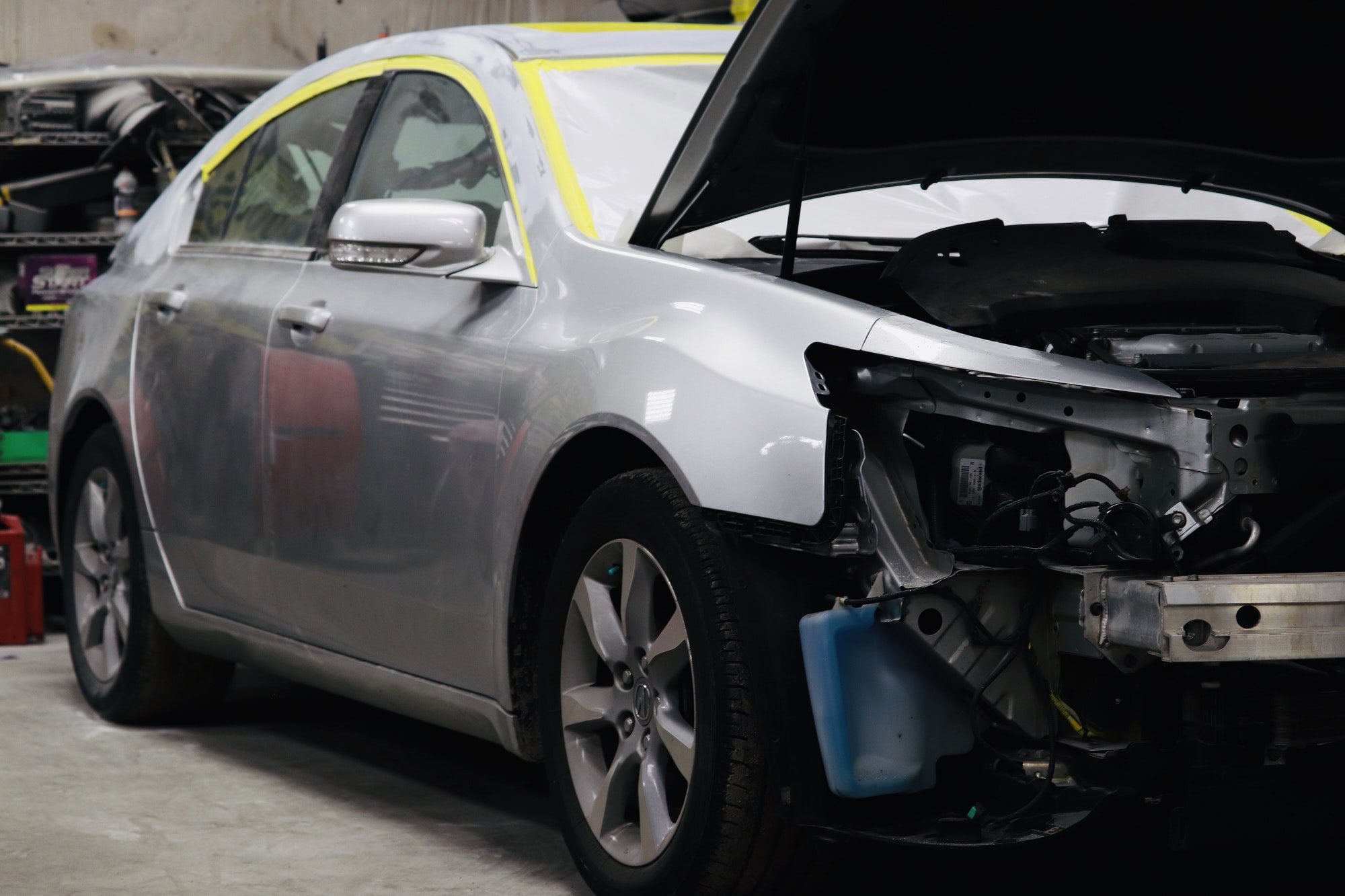 Car repair of an automobile in progress at a collision repair shop.