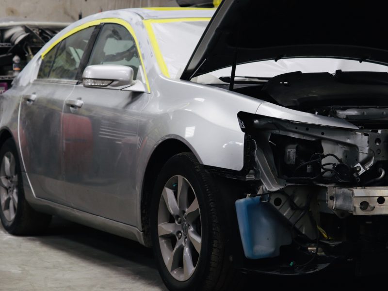 Car repair of an automobile in progress at a collision repair shop.