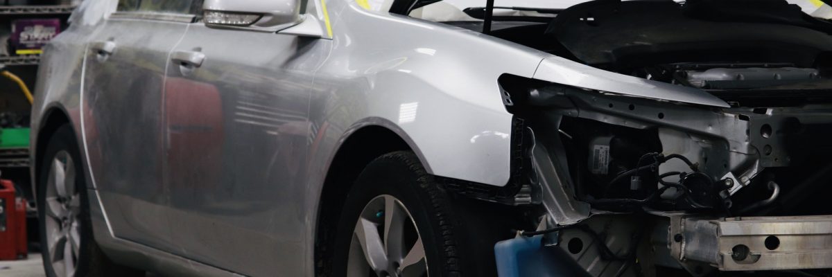 Car repair of an automobile in progress at a collision repair shop.