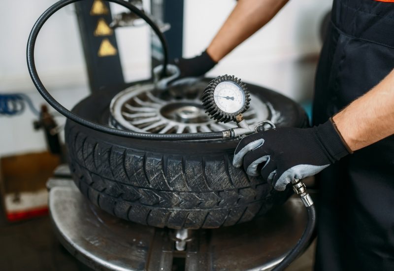 Mechanic inflates wheel, tire repairing service